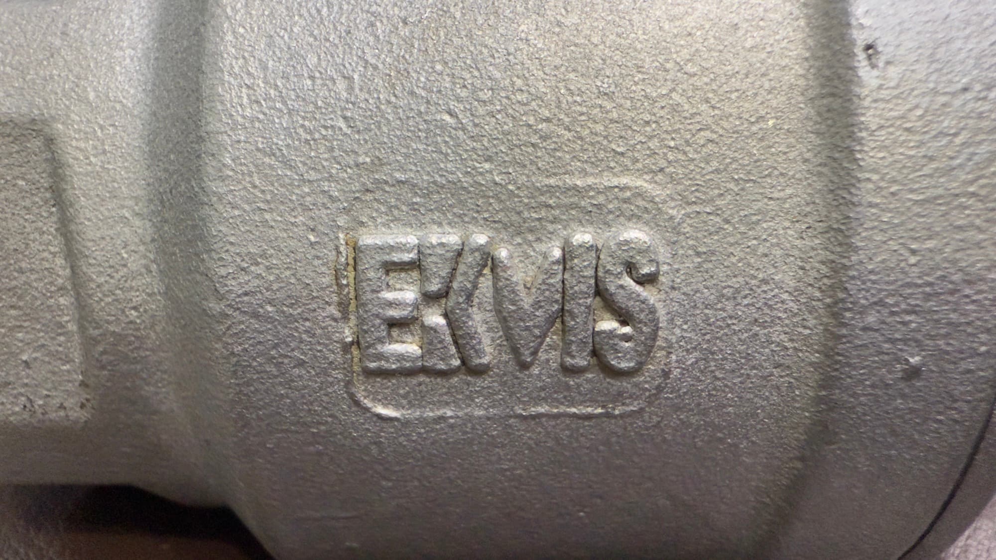 Close-up of the EKVIS mark cast into a stainless steel valve body